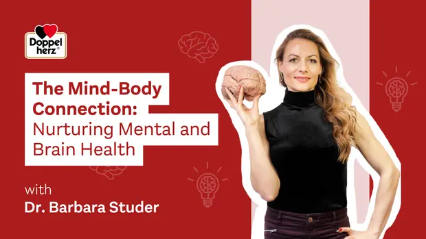 A woman holds a model of a brain while wearing a black shirt. The background features red panels with light bulb illustrations. The text reads "The Mind-Body Connection: Nurturing Mental and Brain Health," alongside "with Dr. Barbara Studer" and the Doppelherz logo.